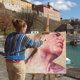 Junge Frau malt ein Bild am Ufer in Meersburg