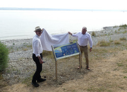 Die Bürgermeister Volker Frede und Daniel Heß enthüllen feierlich eine erste Panoramatafel eines Infotafelprojekts am Hagnauer und Stettener Bodenseeufer. Foto: D. Doer, LEV Bodenseekreis.