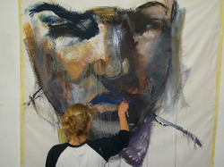 Junge Frau malt ein großflächiges Porträt